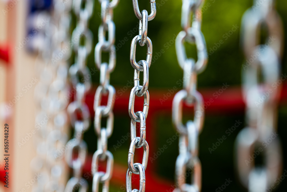metal chains on a background of greenery, close-up metal chains on a background of greenery, close-up