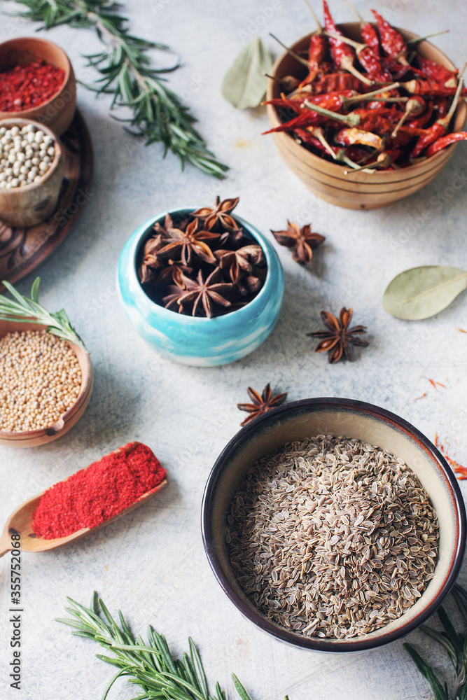 Colorful indian spices and herbs in bowls on light concrete table Colorful indian spices and herbs in bowls on light concrete table