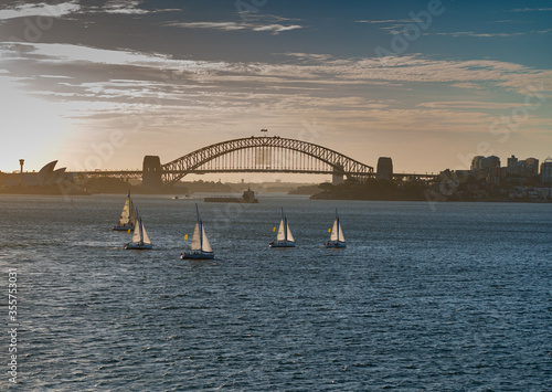 Photography Amazing view of sailboats in Sydney golf at sunset with Sydney Harbour Bridge in