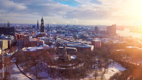 Scenic panorama view from Dancing Towers over Hamburg under snow in winter with St. Michael s Church  German  St. Michaelis   Speicherstadt  river Elbe and New Philharmonic Theater  Elbphilharmony.