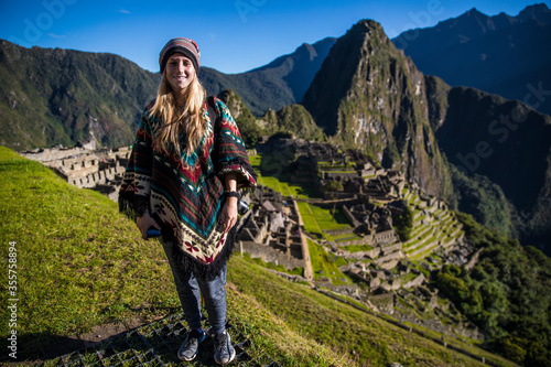 Blonde young woman smiling at the camera in machu picchu