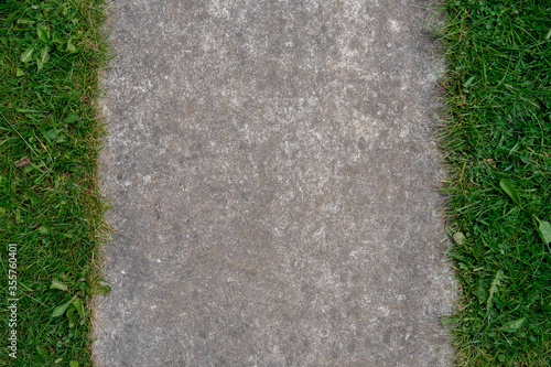 Vertical background of concrete and grass left and right.
