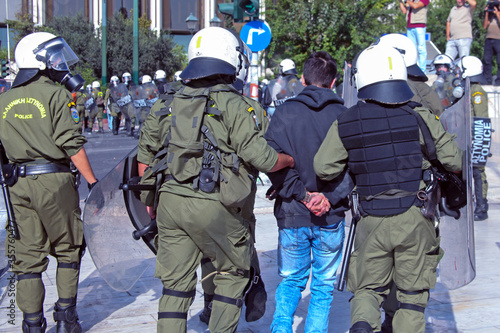 Greek riot policemen have arrested a  young man during riots in Athens, Greece
