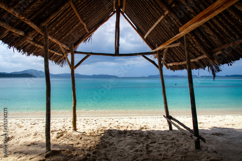 View of the tropical beach from under the awning that protects tourists from the sun
