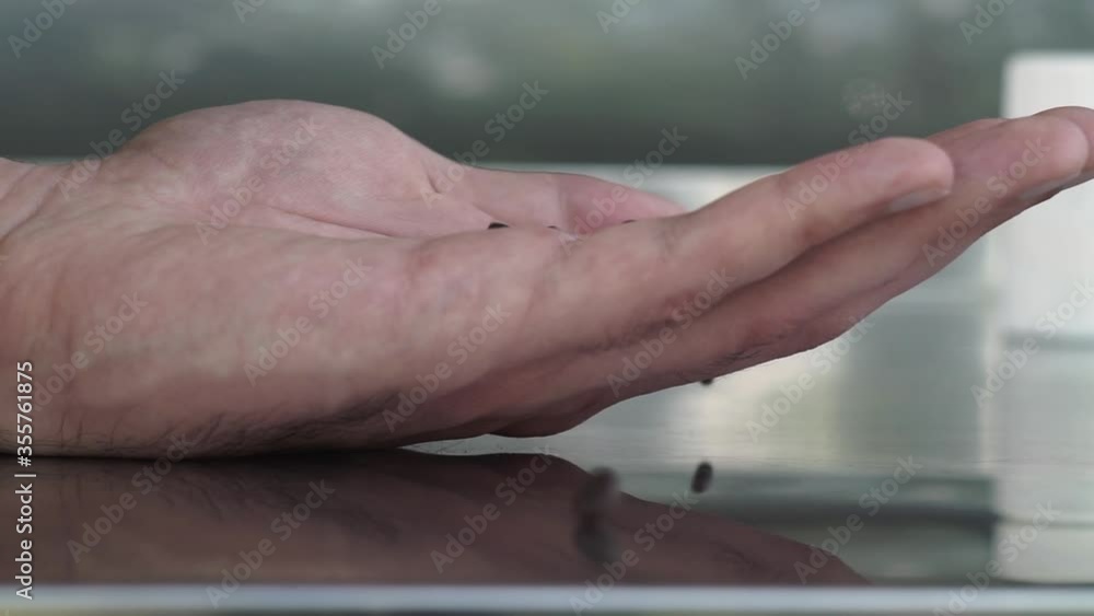 Close up. A lot of brown pills fall in a white hand, palm on a gray background. Close up. A lot of brown pills fall in a white hand, palm on a gray background.