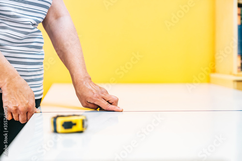 Wallpaper Mural Preparing and measuring the distance between tables in a school academy so that students maintain a safe distance. Reopening and adaptation of schools and academies to the new normal. Torontodigital.ca