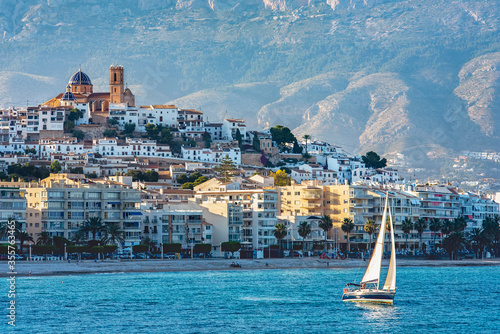 Velero navegando por la costa de Altea - Alicante, España. Pueblo de Altea con velero navengado por su costa. Concepto deporte nautico.  photo