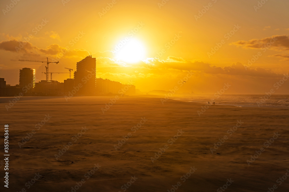 Fototapeta premium The beach of Oostende (Ostend in English) and its skyline at sunset with strong wind along the North Sea, West Flanders, Belgium.