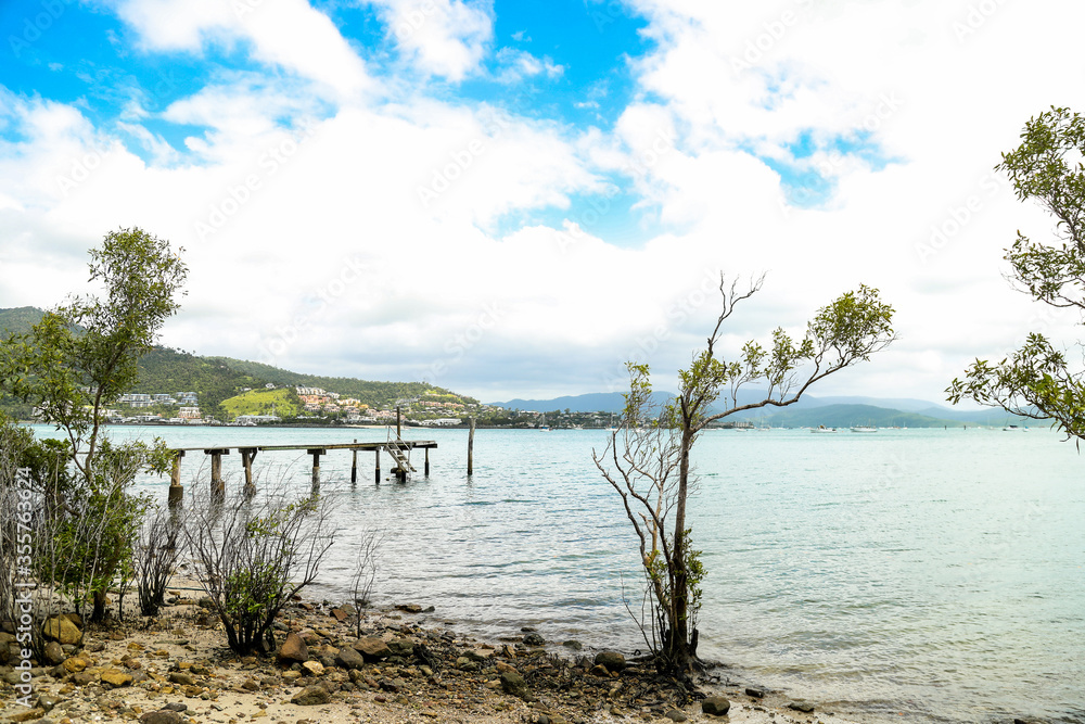 Afternoon view of small rustic wooden jetty at Mandalay off Airlie Beach when the tide is out Afternoon view of small rustic wooden jetty at Mandalay off Airlie Beach when the tide is out