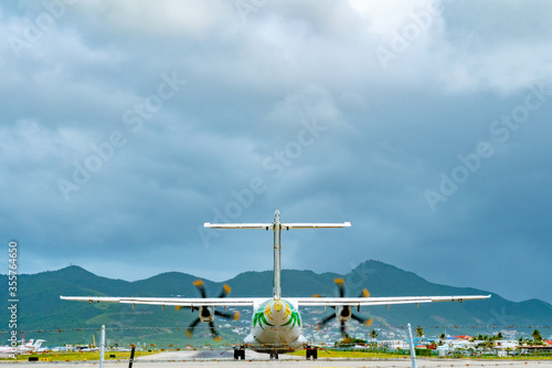 Rear end view of medium twin turbo-prop/  regional aircraft on runway tarmac. photo