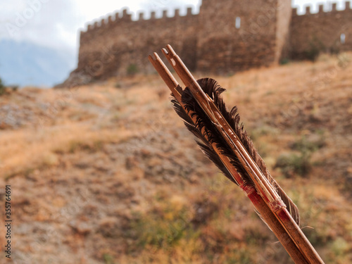 Two bow arrows against the backdrop of ancient Genoese fortress