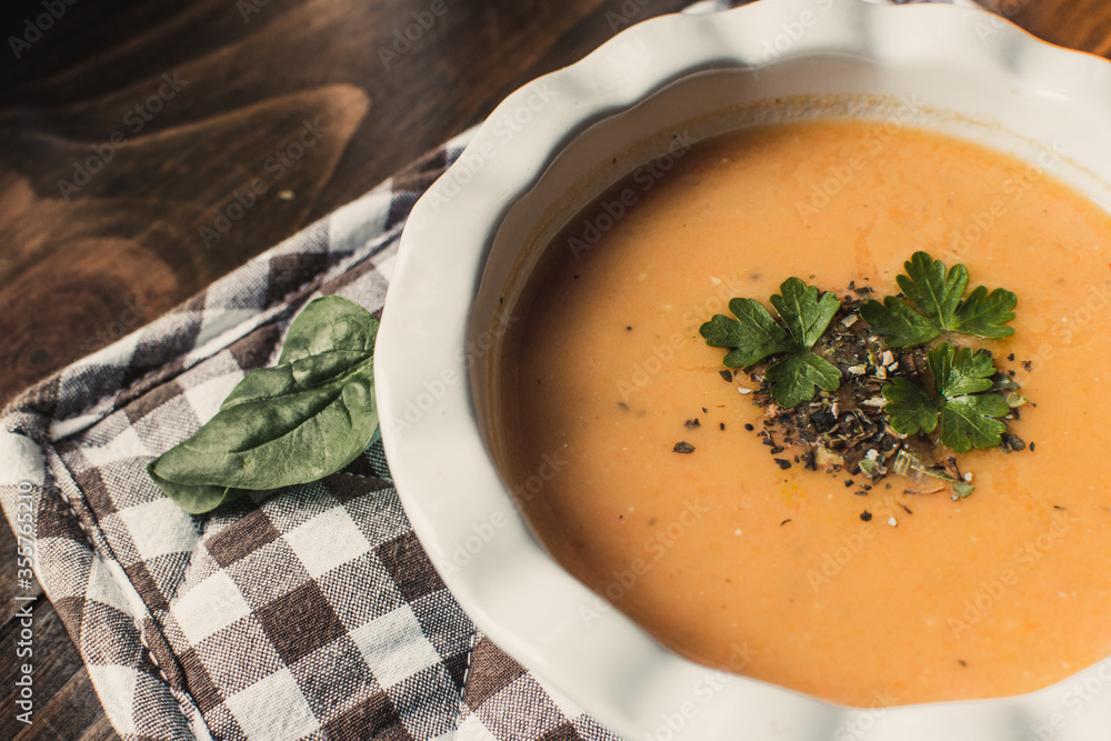 Pumpkin and carrot cream soup on dark wooden background. Top view. Pumpkin and carrot cream soup on dark wooden background. Top view.