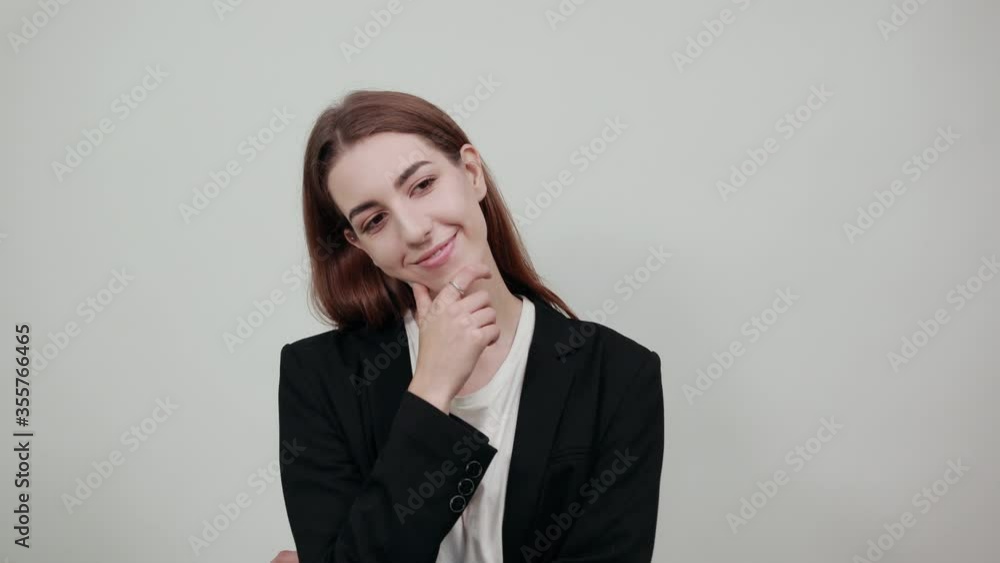 Hand on chin thinking about question, pensive expression. Doubt. Thoughtful face. Using that incredibly sharp business mind. Young attractive woman with brown hair in a light t-shirt and black jacket Hand on chin thinking about question, pensive expression. Doubt. Thoughtful face. Using that incredibly sharp business mind. Young attractive woman with brown hair in a light t-shirt and black jacket