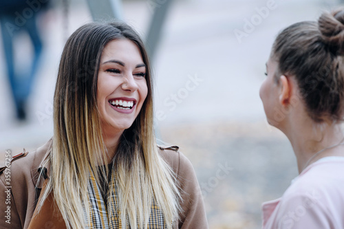 two young women talking and smiling about something