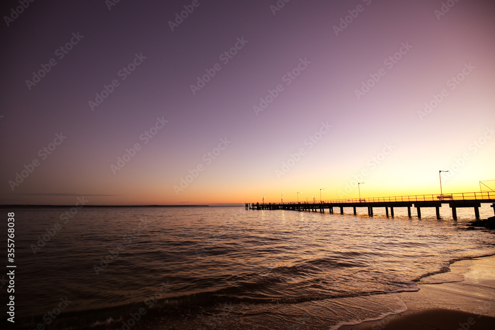 Long jetty into beach at sunset