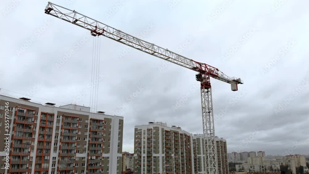 Tower crane with trolley load girder boom. Jib crane trolley and linear traverse. Drone view of the construction site with a crane height Tower crane with trolley load girder boom. Jib crane trolley and linear traverse. Drone view of the construction site with a crane height