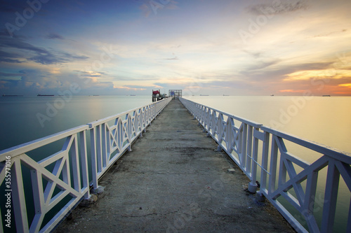 Dusk sky scenery at seascape with long jetty background.