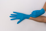 Unrecognizable man putting on blue latex gloves.