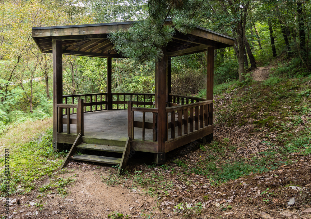 Wooden gazebo in a woodland park Wooden gazebo in a woodland park