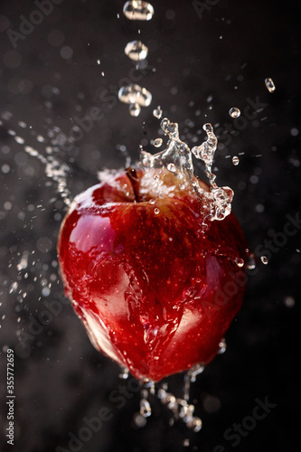 Water splash and fruits isolated on black backgroud. Fresh apple