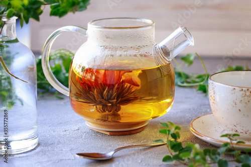 Bright photo with teapot with blooming tea