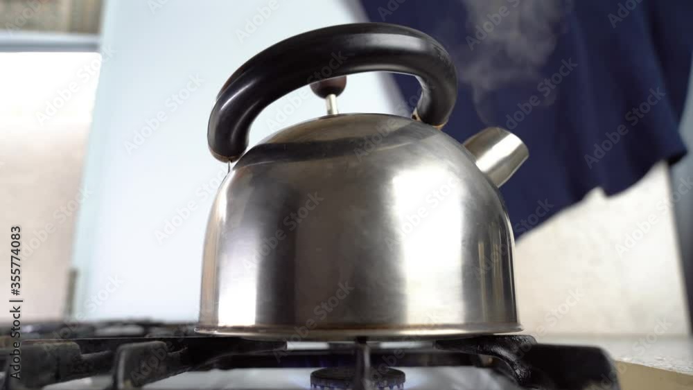Kettle boils on the stove. Steam comes from a boiling kettle Kettle boils on the stove. Steam comes from a boiling kettle