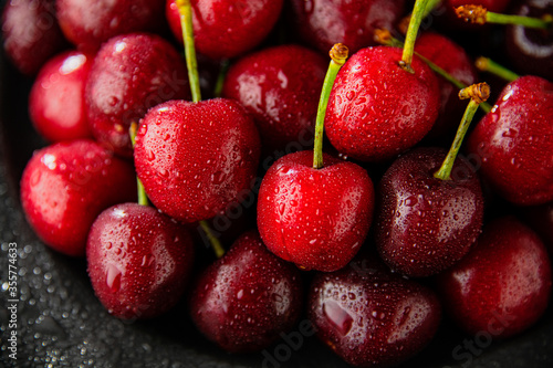 Ripe red cherries in black plate.