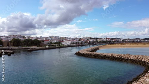 Wallpaper Mural Aerial tilt down shot of canal by street and buildings in city against sky, drone flying forward over city on sunny day - Lagos, Portugal Torontodigital.ca