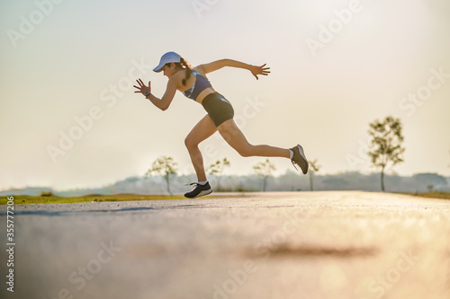 Young women runner run on the road during sun rise