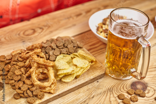 A glass of beer and different snacks on the table. Celebrating international beer day or Octoberfest. Drinking beer after a hard working day or week