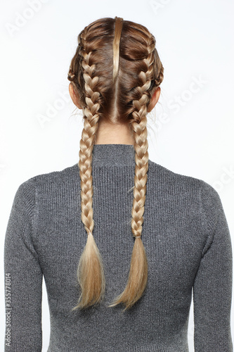 Konstfotografi back view portrait of blonde female with creative braid hairdo.
