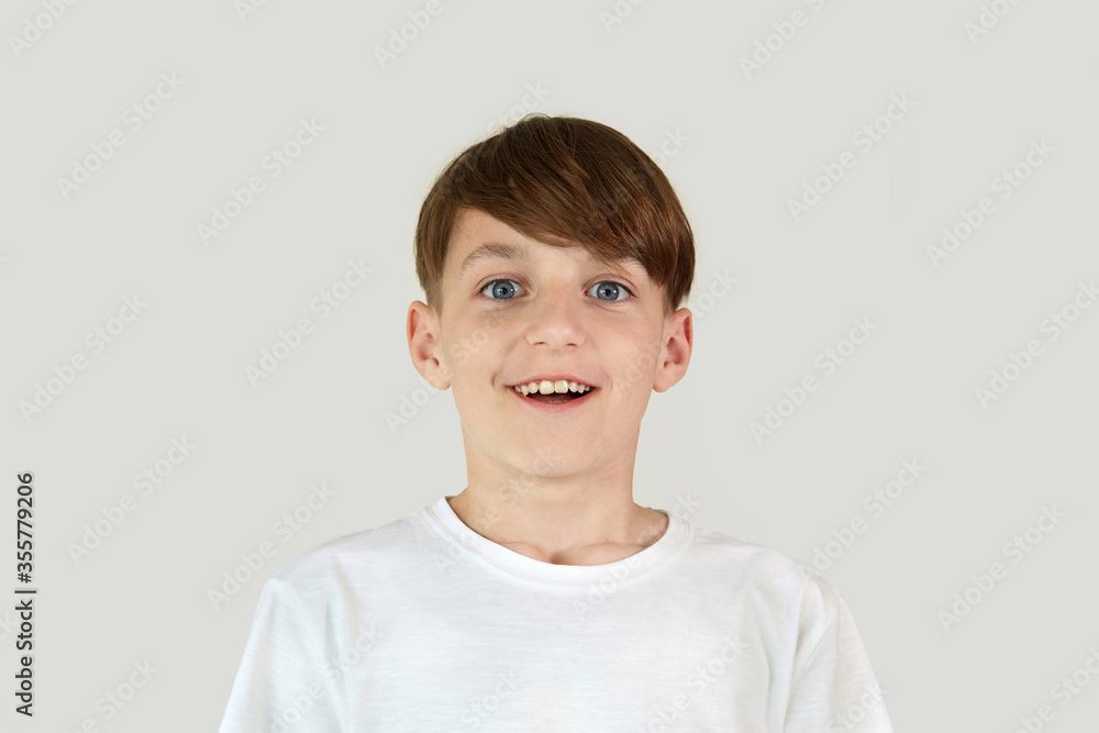 A handsome boy with a broad smile in a white T-shirt. Dark hair. A handsome boy with a broad smile in a white T-shirt. Dark hair.