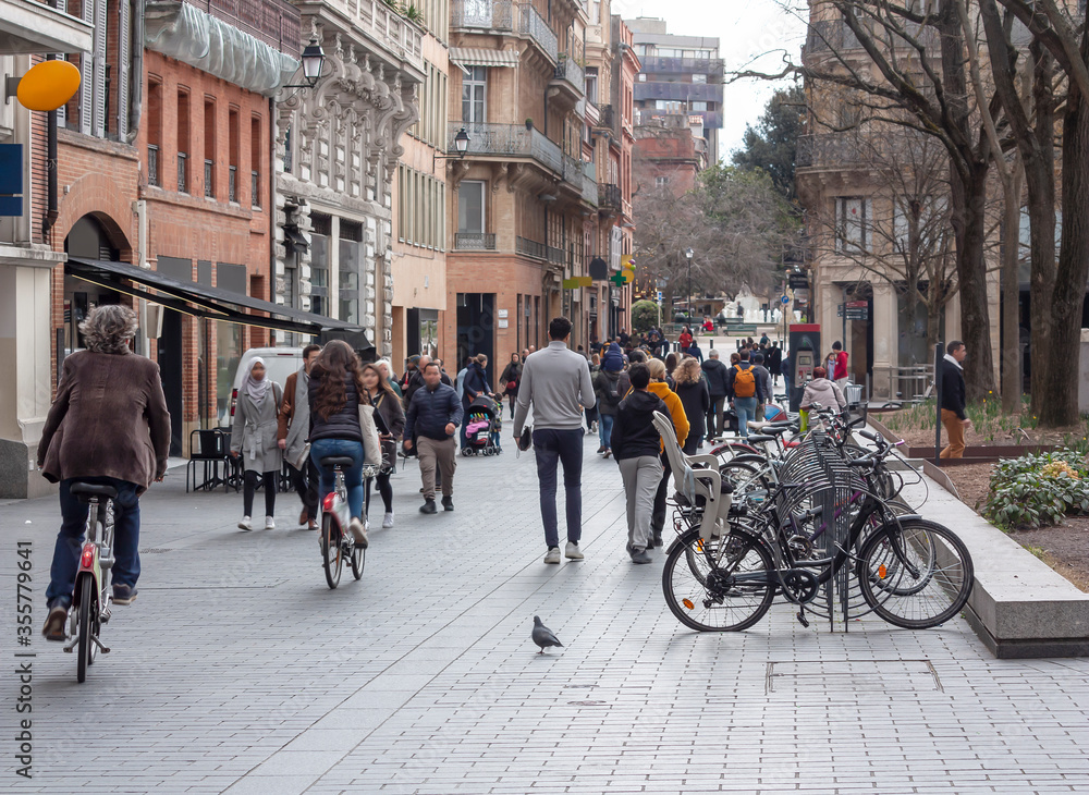 Street of the old european city with walking and cycling people