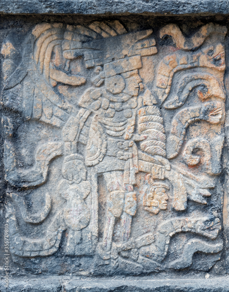 Bas relief of a Mayan Ball Game player with knee, elbow and hip protection and head of a sacrificed player in left hand, Chichen Itza, Mexico.