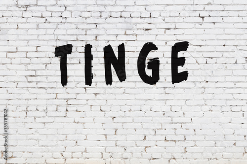 Fotografija Word tinge painted on white brick wall