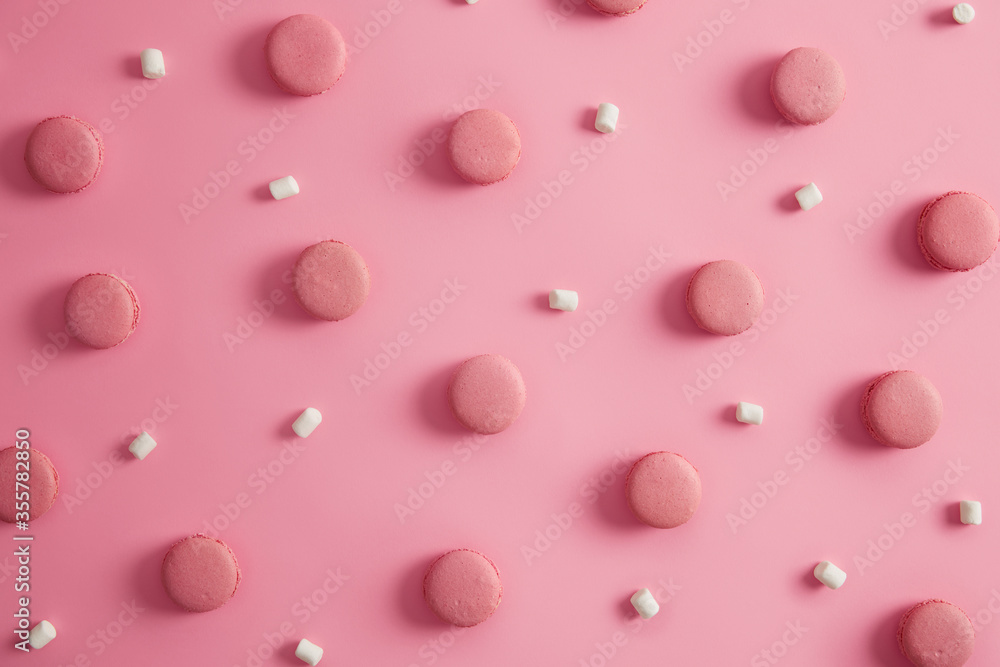 French sweet macaroons of round shape with white marshmallow on pink background. Yummy traditional French dessert. Macarons in one color. Delicious cookies as treat for holiday. Junk food concept French sweet macaroons of round shape with white marshmallow on pink background. Yummy traditional French dessert. Macarons in one color. Delicious cookies as treat for holiday. Junk food concept