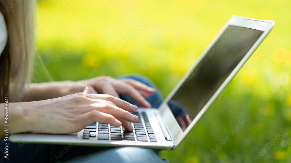 Fototapeta premium Close-up of female hand typing on laptop