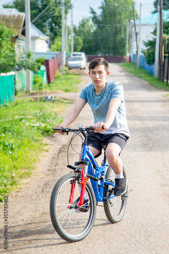 young man rides a bicycle in the countryside