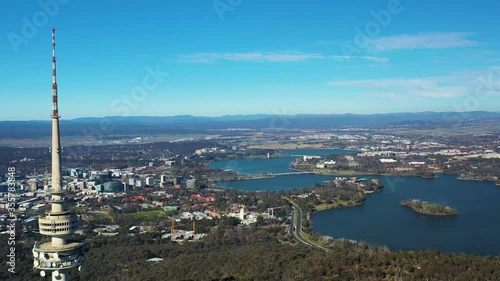 Aerial flyby of Telstra Tower in Canberra, the capital of Australia, showing a panoramic view of Lake Burley Griffin and surrounding landmarks and countryside        photo