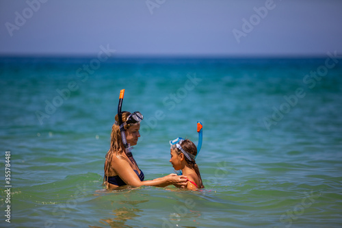 Mom with a daughter in masks for snorkeling