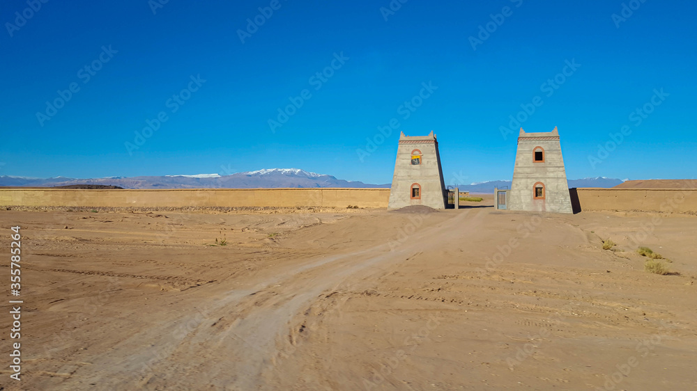 A panoramic view of typical Moroccan gates and Atlas mountains background. Marrakech,  Morocco. 