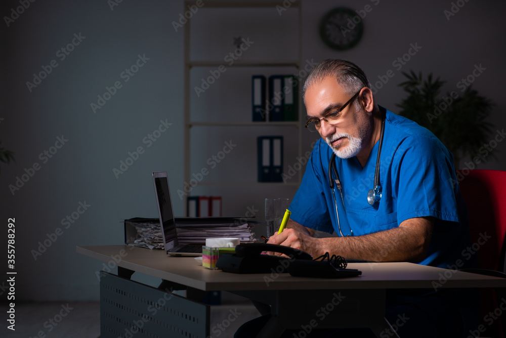 Aged male doctor in the hospital at night Aged male doctor in the hospital at night