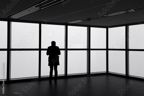 a man's silhouette standing in front of the window.