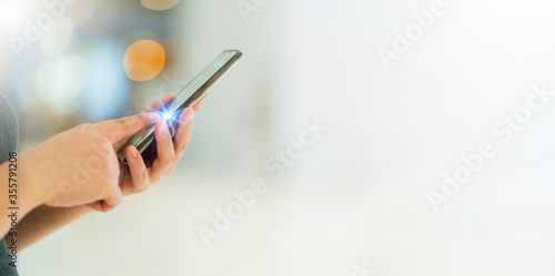 closeup hand press functional button smartphone technology communication with abstract blur bokeh background