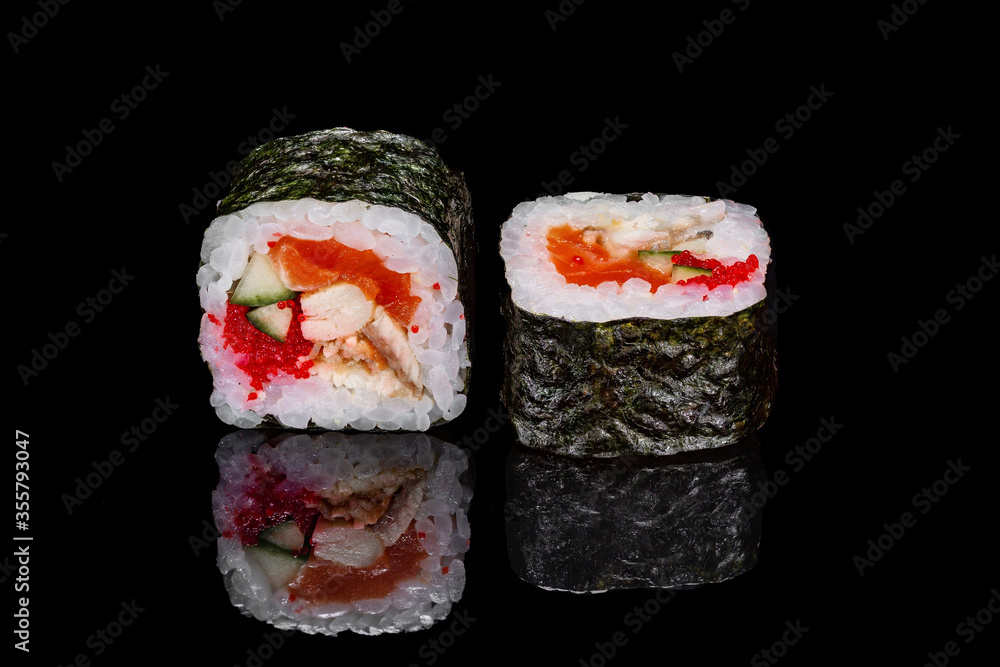 Sushi and rolls on a black mirrored background. Sushi and rolls on a black mirrored background.