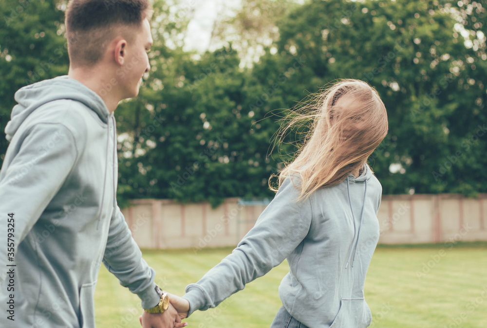 Girl leads a guy's hand,Girl leads a guy by the hand in the stadium and smiles
Girl leads a guy's hand,Girl leads a guy by the hand in the stadium and smiles