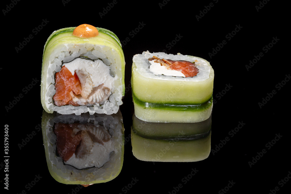 Sushi and rolls on a black mirrored background. Sushi and rolls on a black mirrored background.