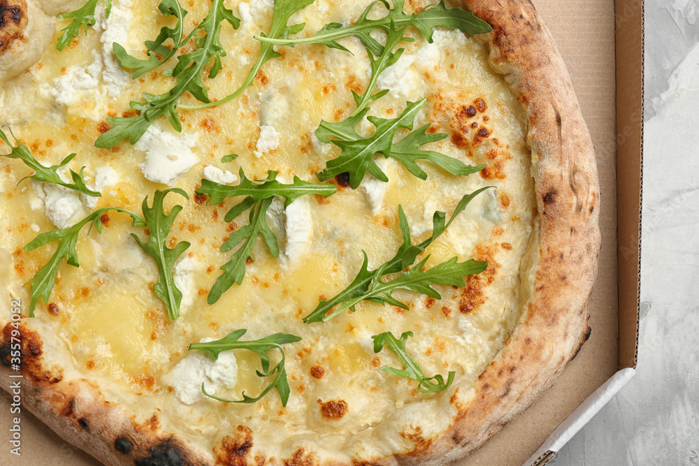 Delicious cheese pizza with arugula in takeout box, closeup Delicious cheese pizza with arugula in takeout box, closeup