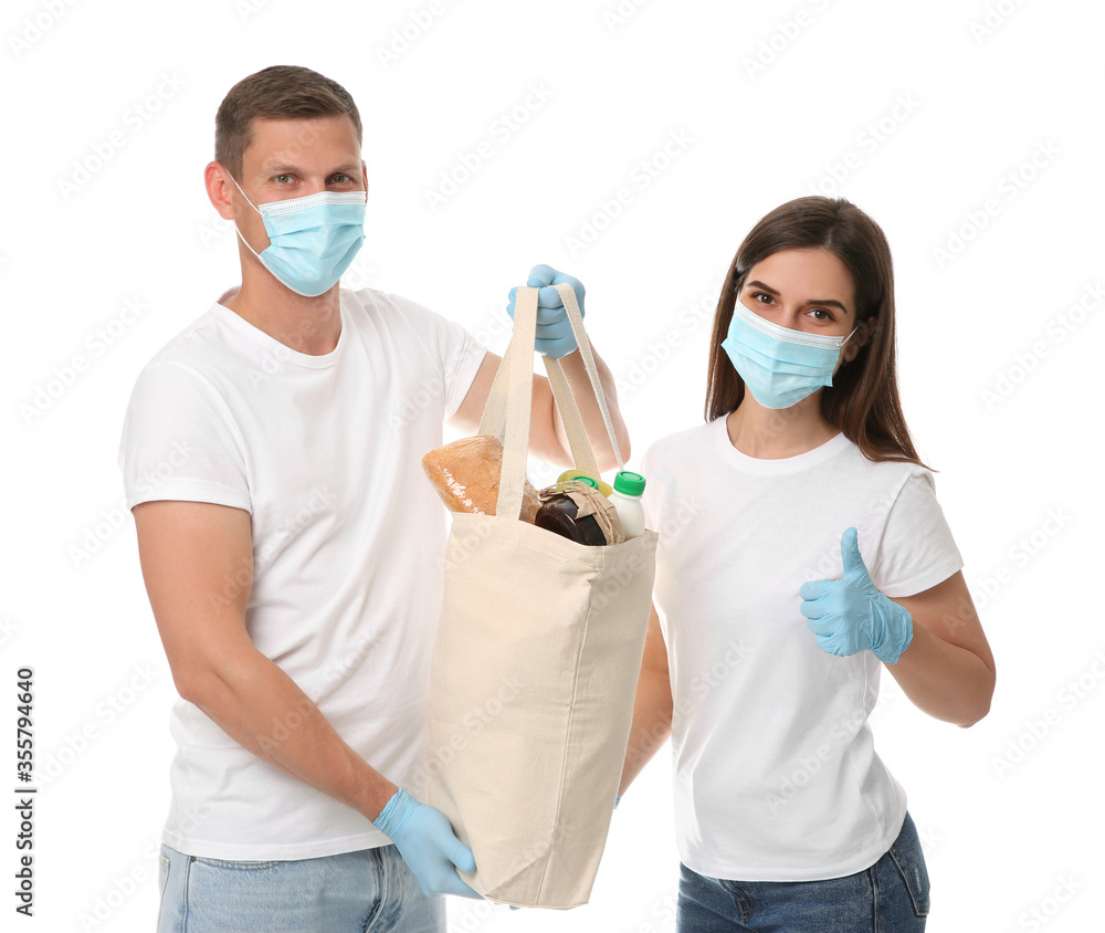 Volunteers in protective masks and gloves with products on white background. Aid during coronavirus quarantine