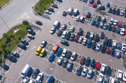 Plenty of cars in the packed parking lot in straight rows from a bird's-eye view photo
